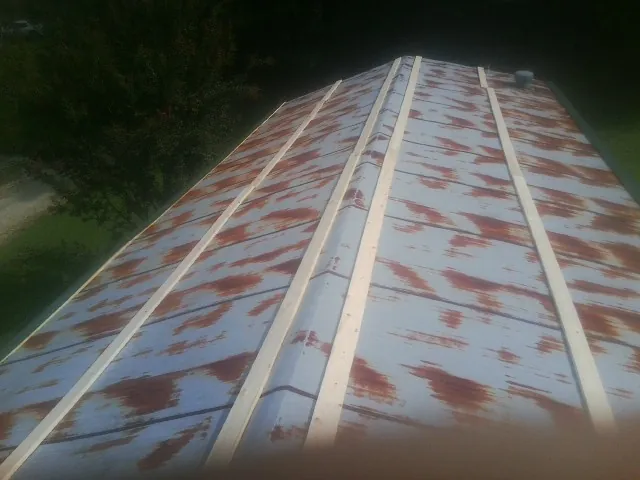 Rusted metal roof panels with new wood purlins before replacement — Storm Damage Roof Repair in Ipava by Roofing Brothers